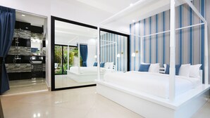 Une chambre moderne avec un grand lit, une porte en verre donnant sur une salle de bain et une vue sur l’extérieur.