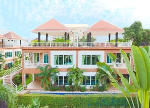 A multi-story hotel with a central courtyard, balconies, and a swimming pool.