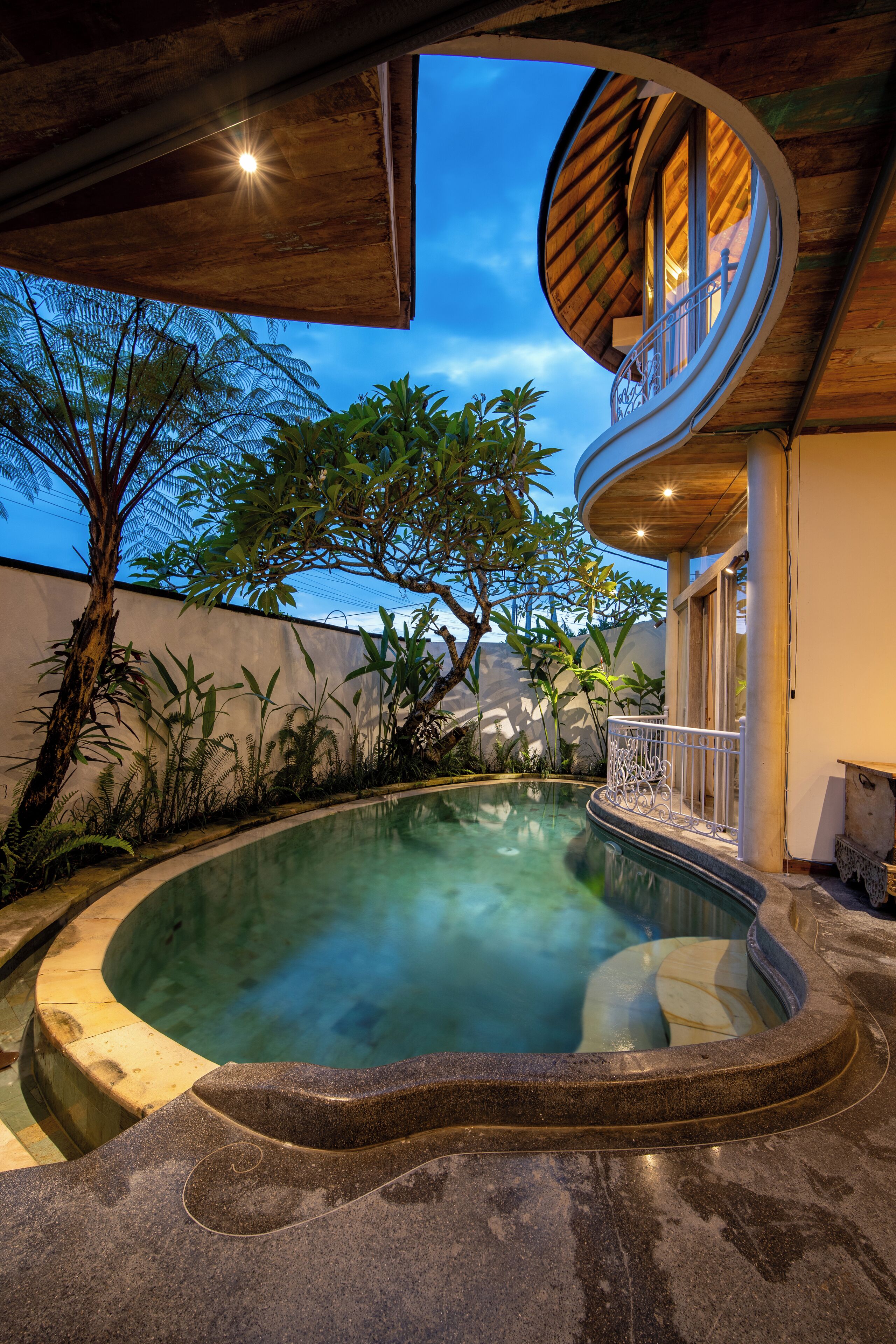 A circular hot tub with a curved edge, surrounded by a stone deck.