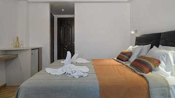 Una habitación de hotel con cama, escritorio y puerta.