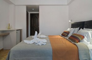Una habitación de hotel con cama, escritorio y puerta.