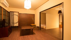 Ein Zimmer mit Holzboden, einem Bett mit Kopfteil, einem Schreibtisch mit Stuhl und einem Kleiderschrank.