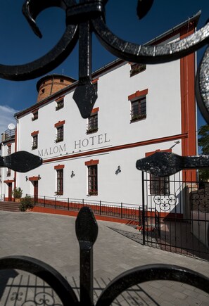 A hotel with a white facade, red trim, and the name 'MALOM HOTEL' displayed. - Malom Hotel és Étterem (Debrecen)