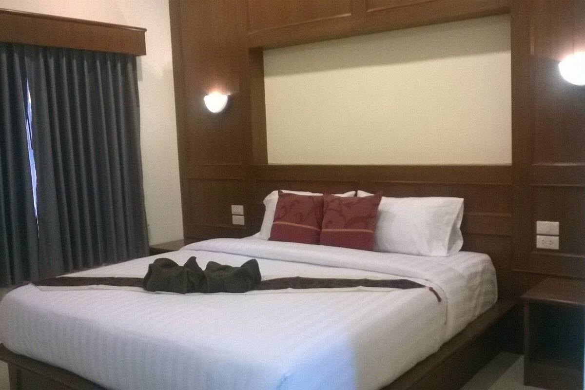 Ein Hotelzimmer mit einem großen Bett, einem Holz-Kopfteil und einem Nachttisch.