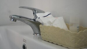 A bathroom sink with a single faucet and a tissue holder. - Tamarind Twin Resort (Ko Lanta)