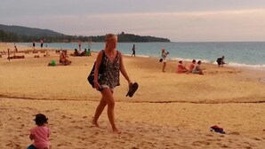 A sandy beach with people walking and sitting. - Tamarind Twin Resort (Ko Lanta)