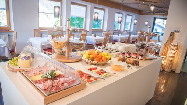 Una mesa de buffet con diversos alimentos y una vitrina de vidrio.