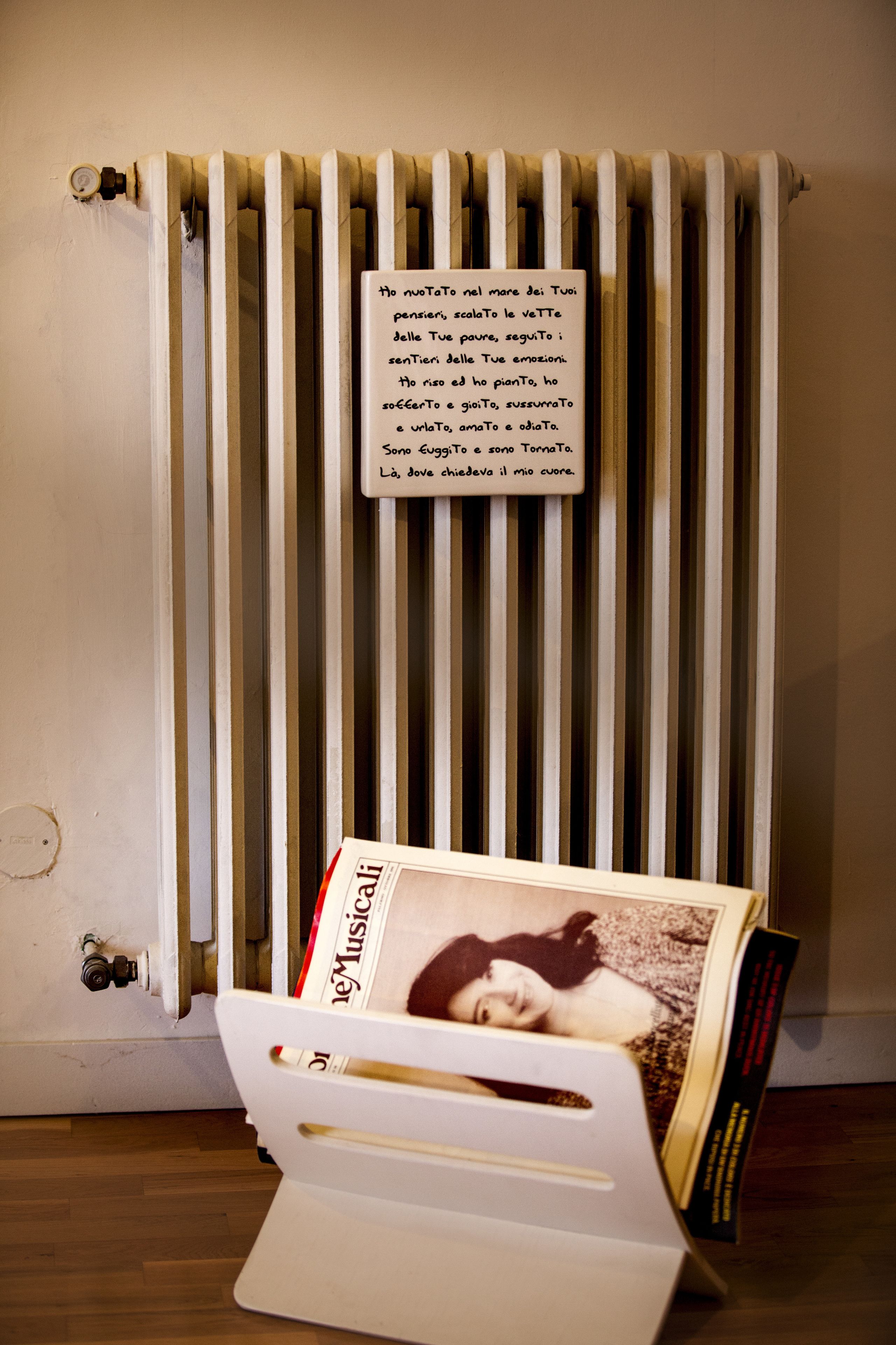 A radiator with a handwritten note and a magazine rack with a magazine.