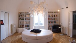 Una sala de estar moderna con un sofá redondo blanco, una estantería y una original lámpara de papel.