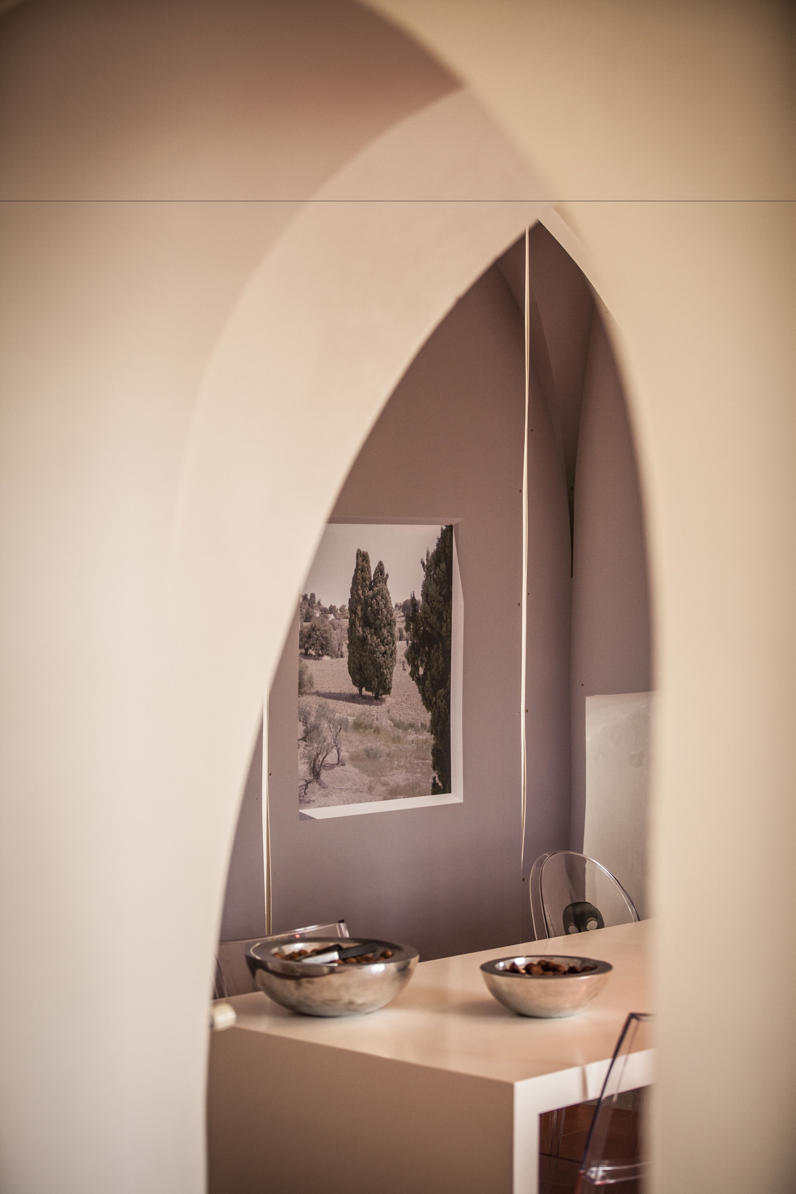 Uma área de refeições com mesa, cadeiras e um quadro na parede.