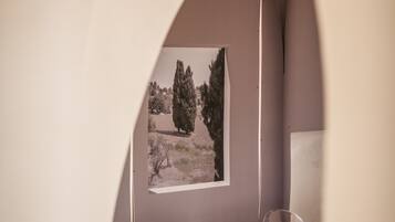 Uma área de refeições com mesa, cadeiras e um quadro na parede.