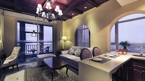 Ein modernes Hotelzimmer mit Balkon, einer Essecke und einer Sitzecke mit Sofa und Sesseln.