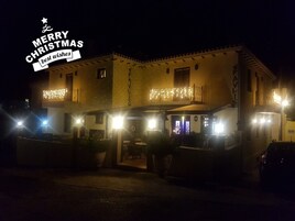 Un edificio con un letrero que dice "MERRY CHRISTMAS best wishes" y luces en su fachada.