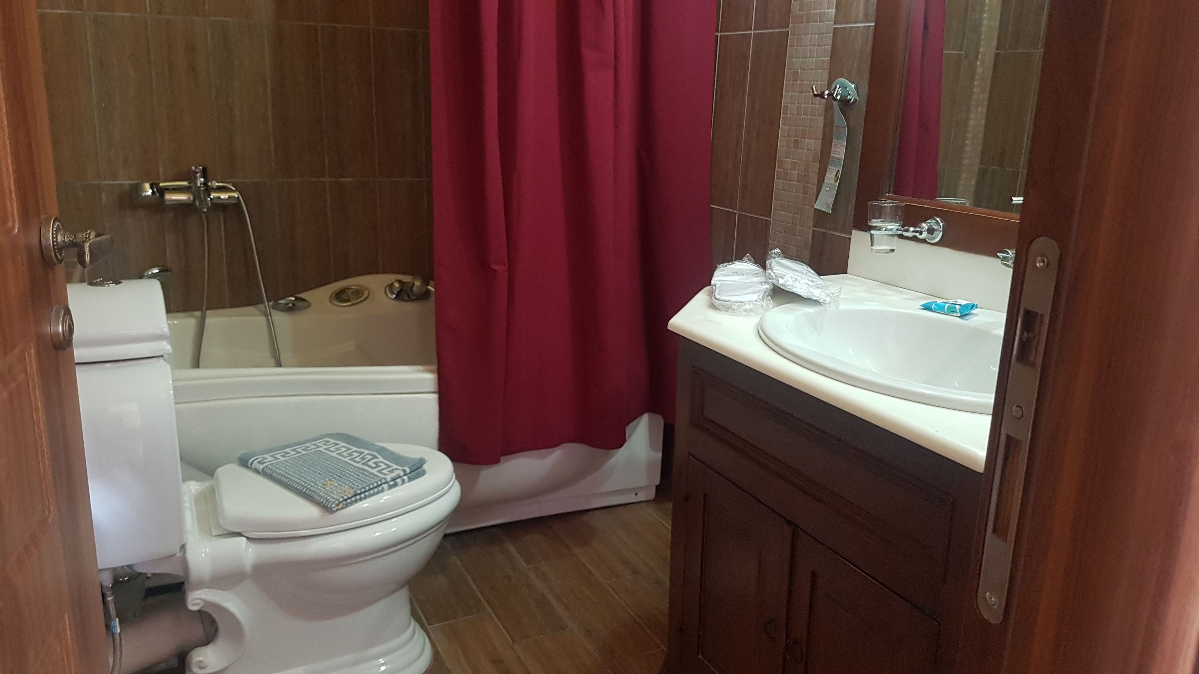 A bathroom with a toilet, bathtub, and a sink with a mirror.