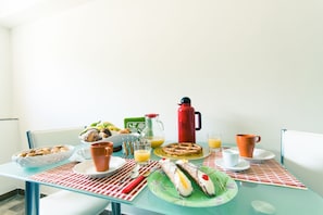 A breakfast table with various food items, a pitcher, and cups. - B&B A Mare (Castellammare del Golfo)