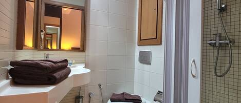 Un baño moderno con lavamanos blanco, inodoro y zona de ducha.