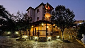 Una casa de dos pisos con balcón, un camino de piedra e iluminación exterior.
