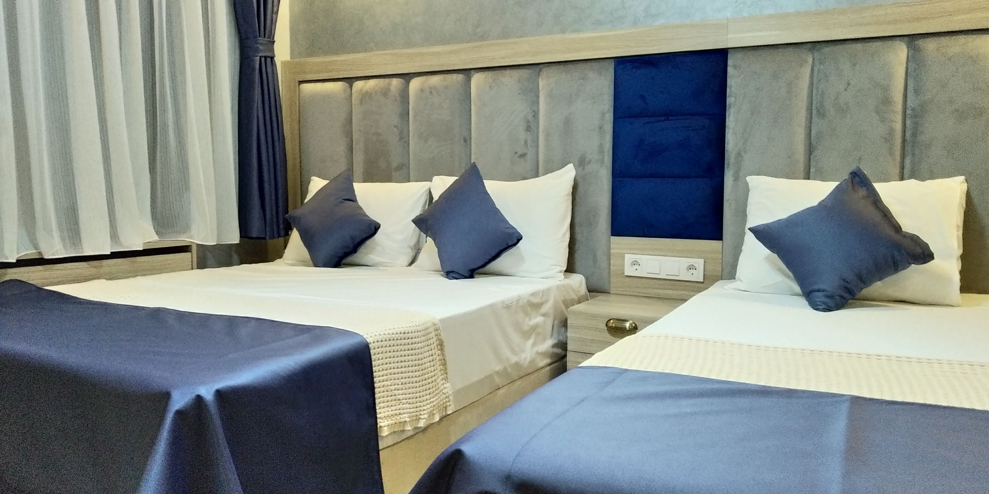 Una habitación de hotel con dos camas, una mesita de noche y una silla.