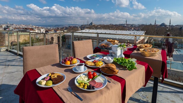 A table set with a variety of food items and a view of a cityscape.