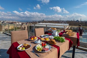 Una mesa servida con diversos alimentos y vista a un paisaje urbano.
