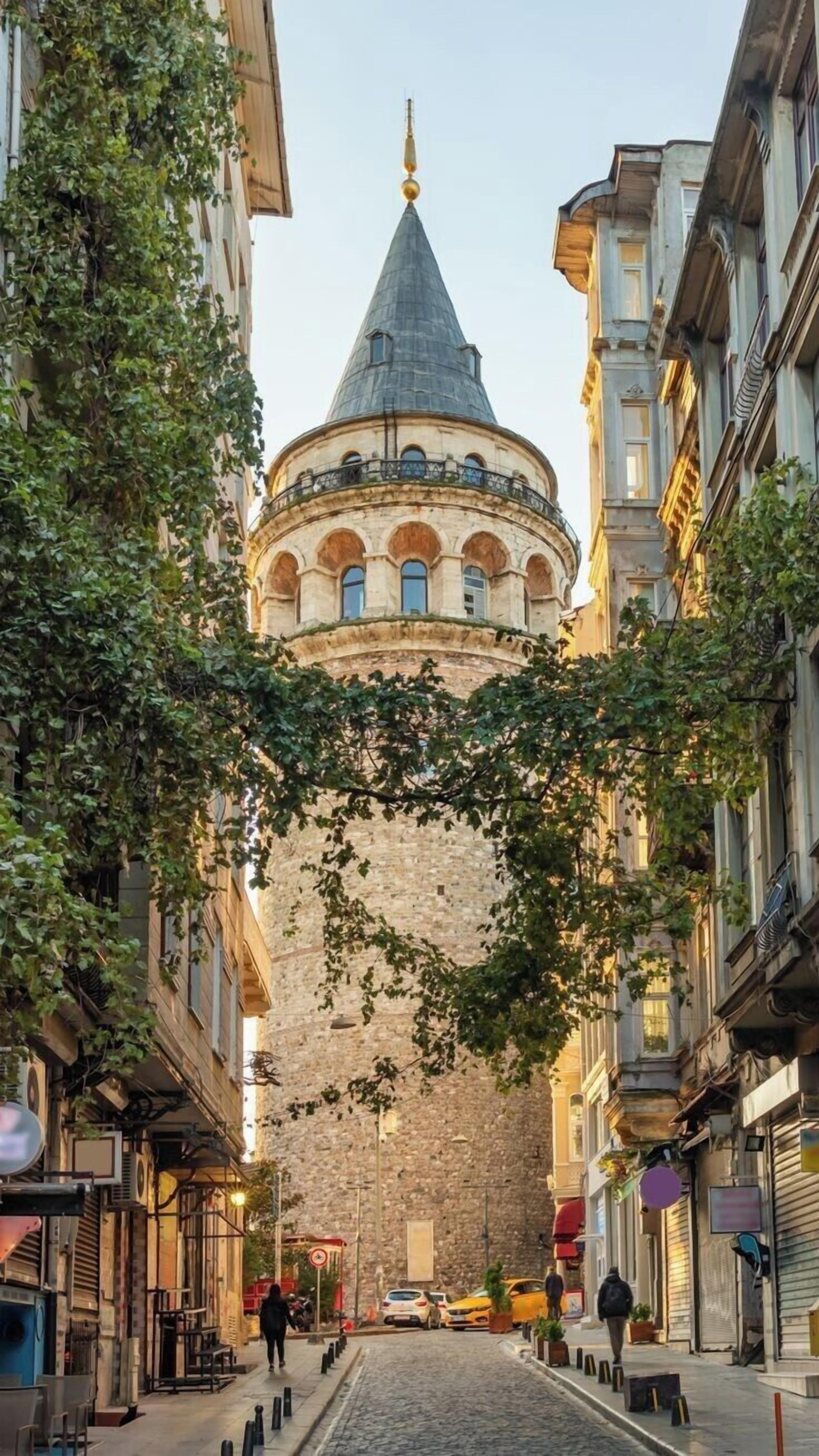 Une rue menant à un bâtiment historique doté d’un dôme imposant et de murs en pierre.