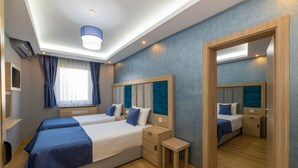 A hotel room with two beds, a small table, and a mirror.