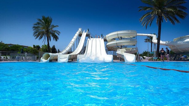 A water park with multiple slides and a pool.