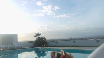 A pool with a clear view of the sky and distant landscape.