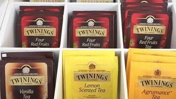 A box of Twinings tea varieties including Four Red Fruits Tea, Vanilla Tea, Lemon Scented Tea, and Agrumance Tea.