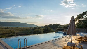 Una piscina con vistas a montañas y un campo cubierto de hierba.