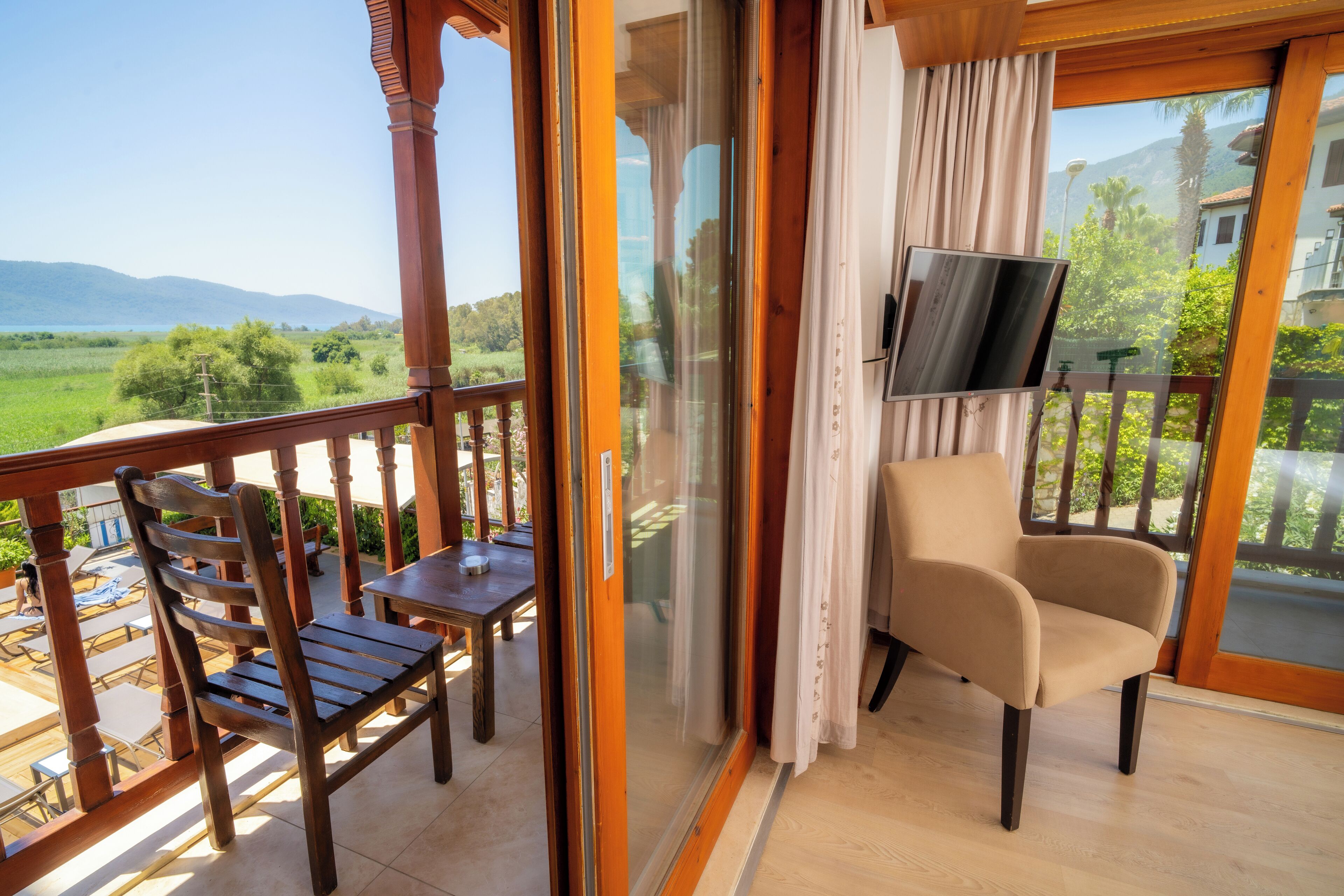 A balcony with a wooden chair, a table, and a TV.