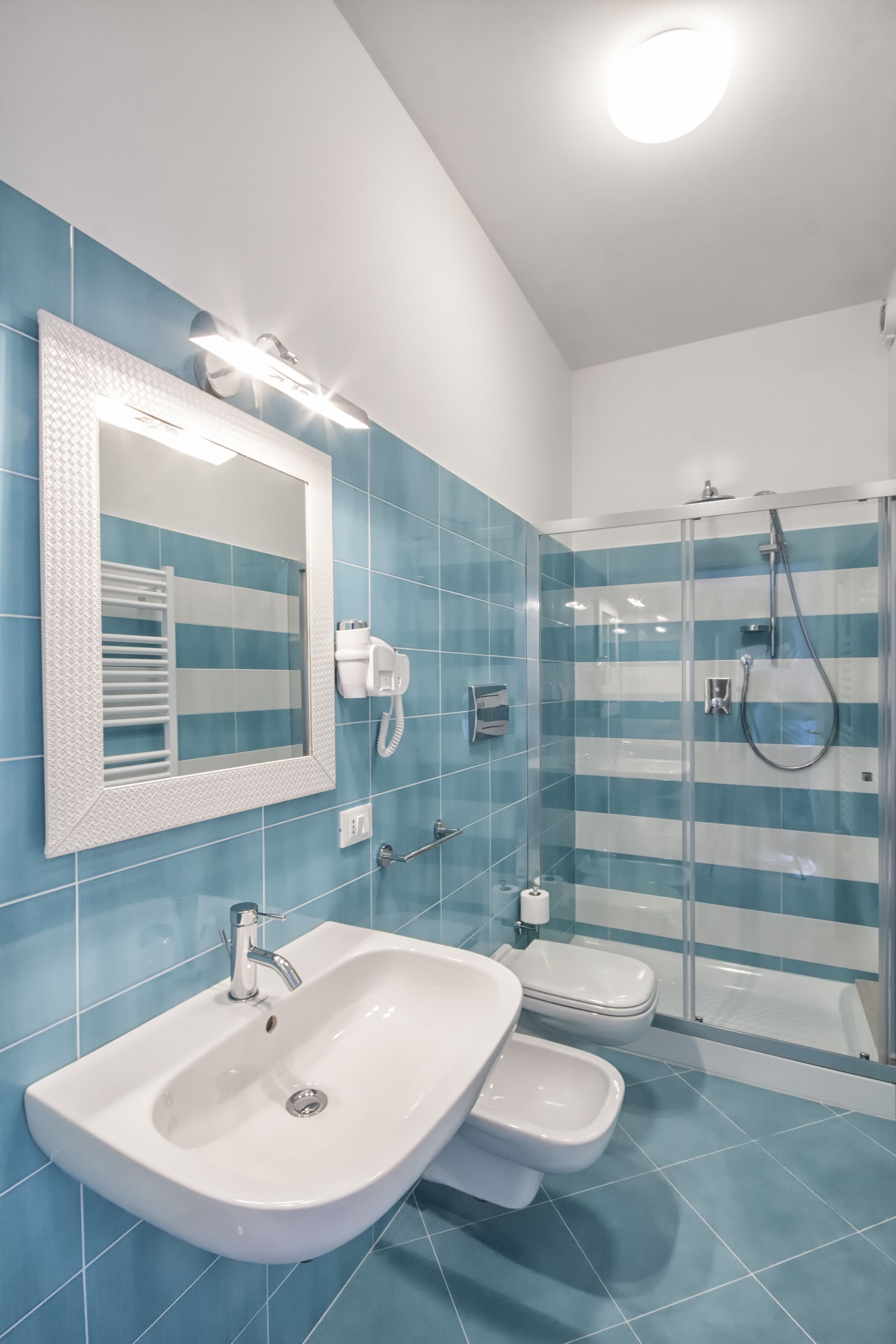 A modern bathroom with a large sink, a toilet, and a glass shower enclosure.