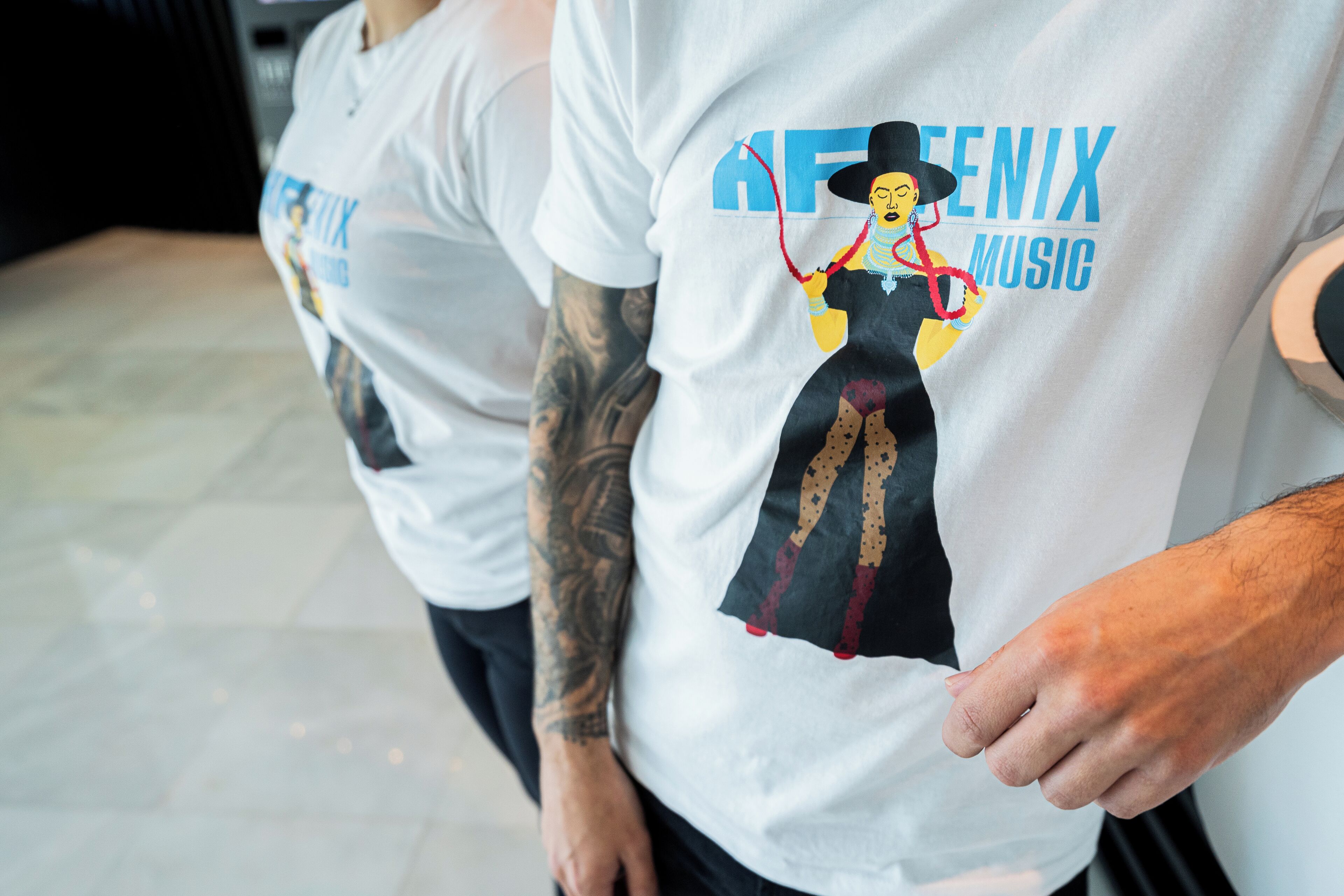 Two people wearing white t-shirts with a graphic and text.