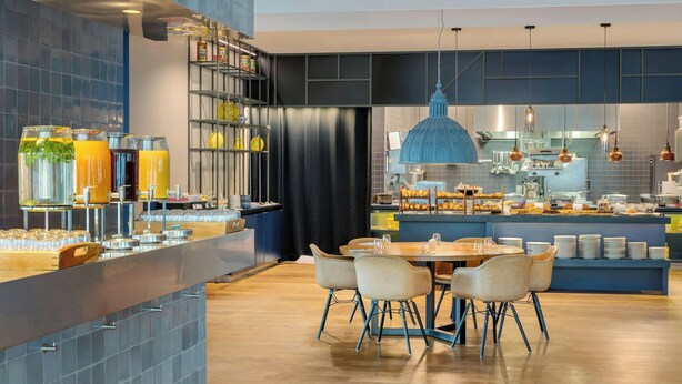 Una cocina moderna con una isla central, barra y asientos para comer.