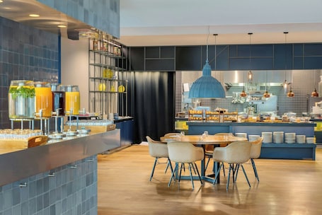 A modern kitchen with a central island, bar area, and seating for dining.