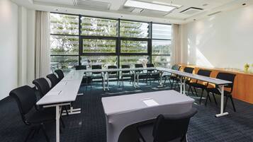 A conference room with a long table, multiple chairs, and a projector screen.
