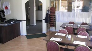 A conference room with tables, chairs, and a reception desk. - Prospect Inn (Fredericton)