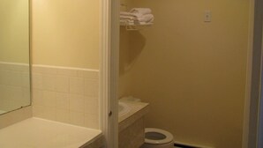 A bathroom with a toilet, a sink, and a towel rack. - Prospect Inn (Fredericton)