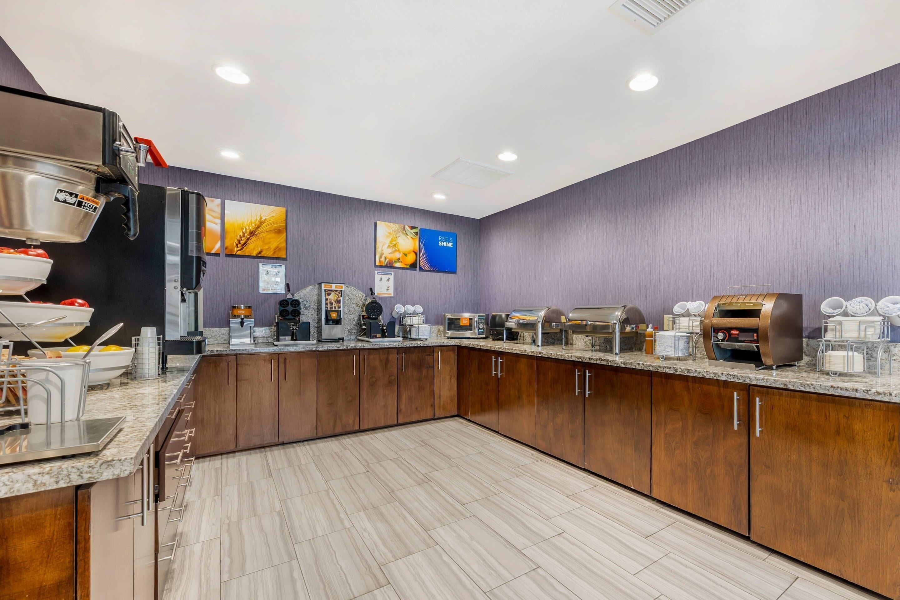 A modern kitchen with a marble countertop, coffee machines, and a large sink.