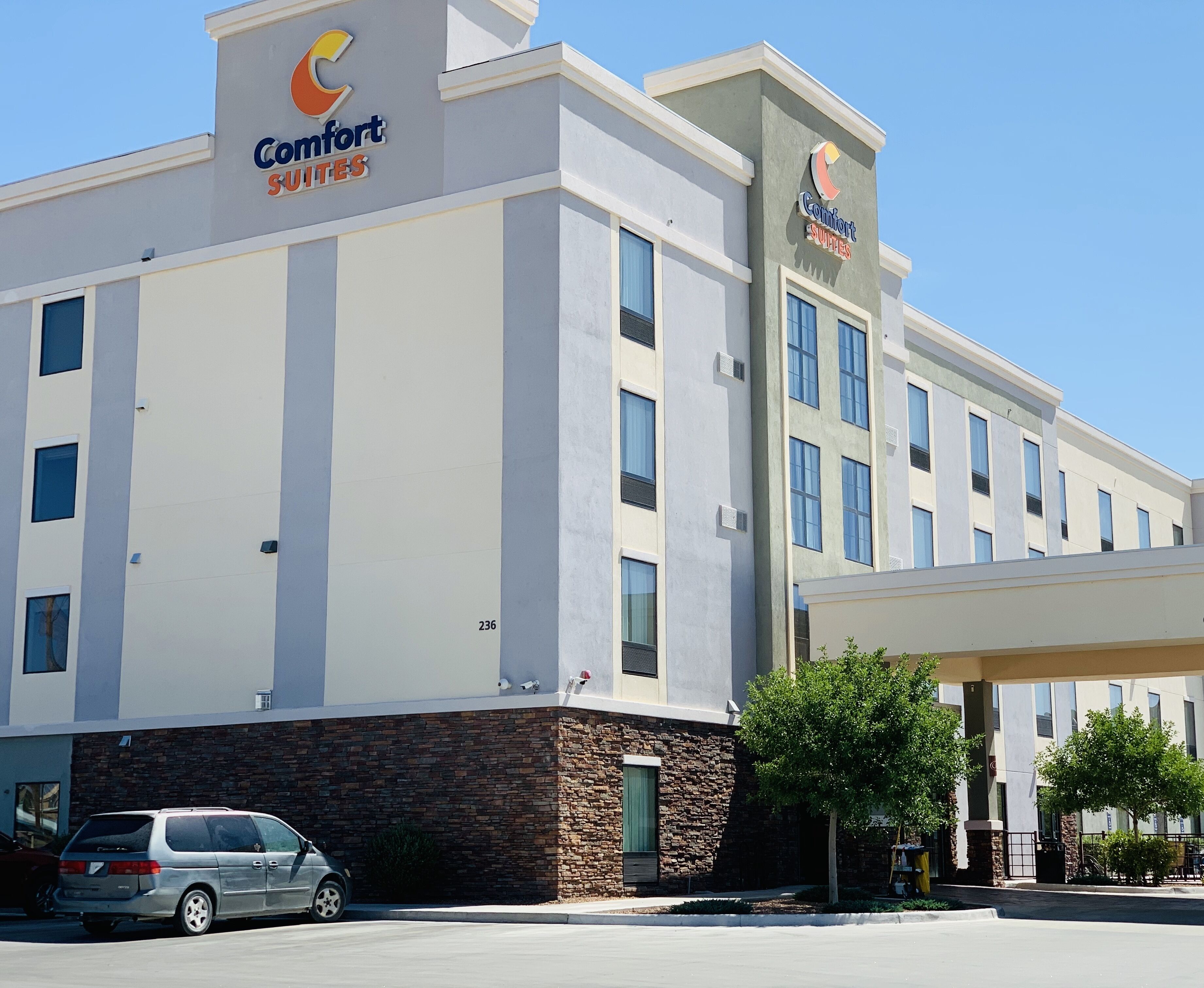 A Comfort Suites hotel with a modern design, featuring a brick facade and multiple windows.