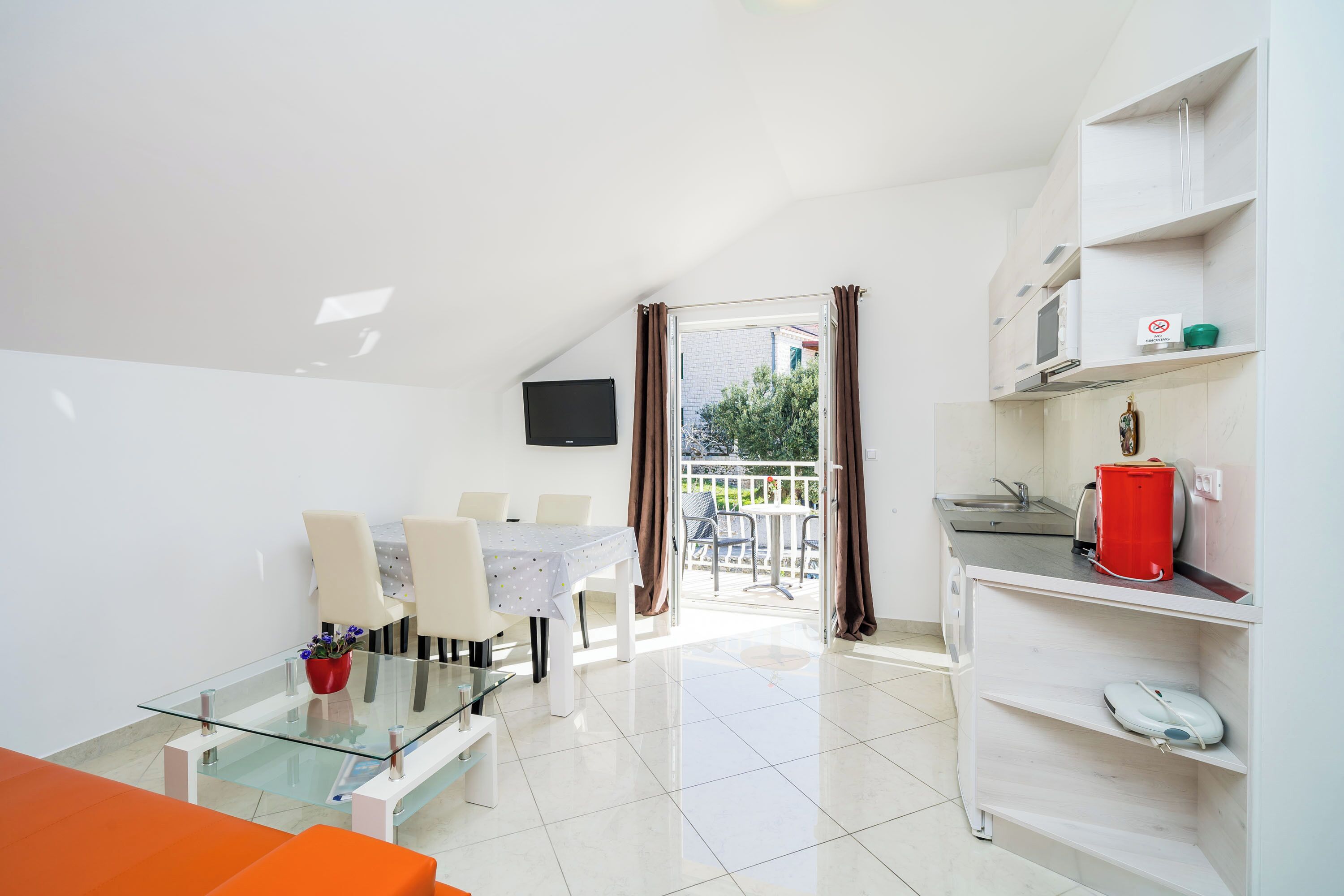 Un appartement moderne comprenant un coin repas, une cuisine et un balcon.