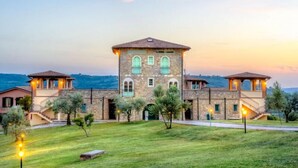 A large stone building with multiple levels and a central courtyard. - Pian Dei Mucini Resort Le Ville (Massa Marittima)