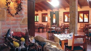 A restaurant with stone walls, wooden beams, and tables set for dining. - Pian Dei Mucini Resort Le Ville (Massa Marittima)
