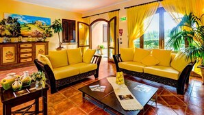 A hotel lobby with yellow sofas, a coffee table with magazines, and a painting on the wall. - Pian Dei Mucini Resort Le Ville (Massa Marittima)