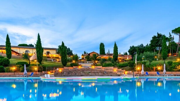 A swimming pool with lounge chairs and a stone staircase leading to a building. - Pian Dei Mucini Resort Le Ville (Massa Marittima)