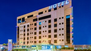 A modern hotel with a prominent 'HOTEL' sign, a well-lit entrance, and a visible 'Plaza Inn HOTEL' sign. - Plaza Inn Breeze Aeroporto (Goiania)