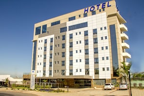 Hotel entrance with covered walkway and parking.