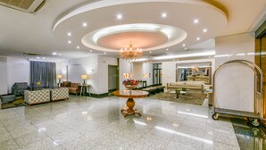 A spacious lobby with a polished marble floor, a central round table with a floral arrangement, and a chandelier. - Plaza Inn Breeze Aeroporto (Goiania)