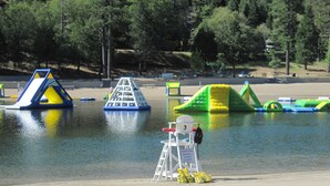 Un parco acquatico con strutture gonfiabili e una postazione di salvataggio.