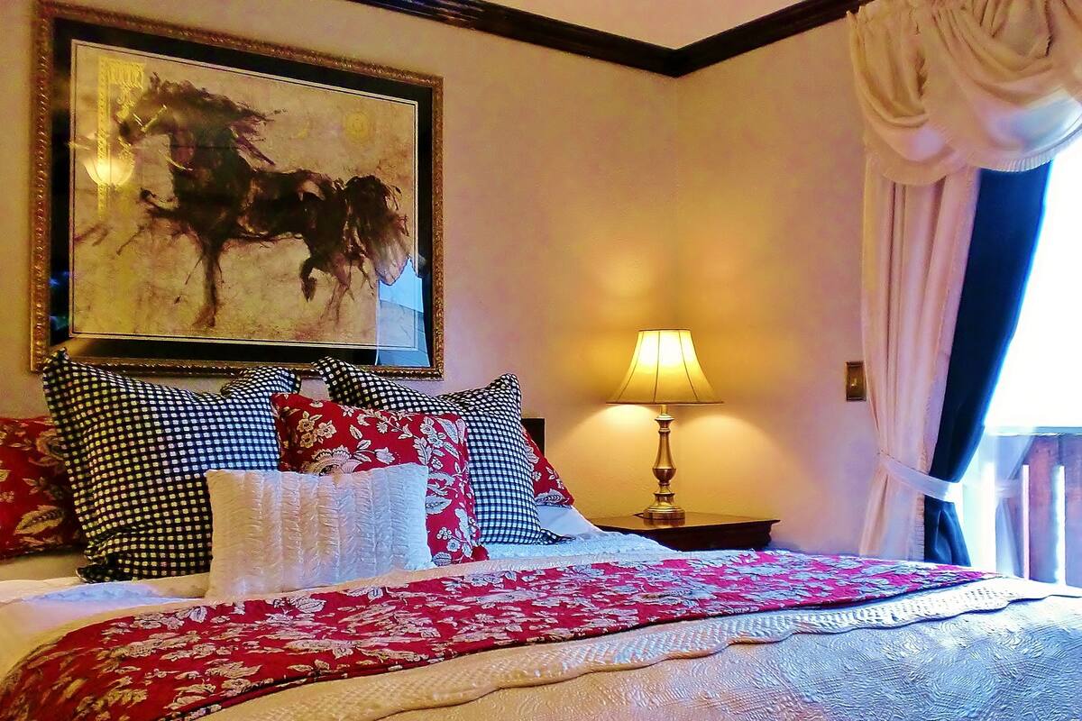Ein Hotelzimmer mit Bett, Nachttisch, Lampe und einem Bild an der Wand.